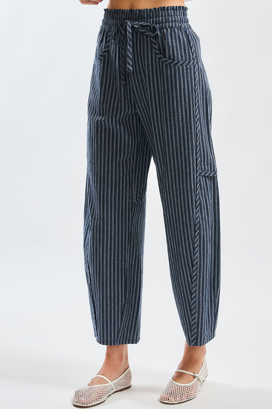 A pair of women's high-waisted wide-leg cropped pants featuring a indigo and white vertical pinstripe pattern with a gathered elastic drawstring waistband and front pockets.