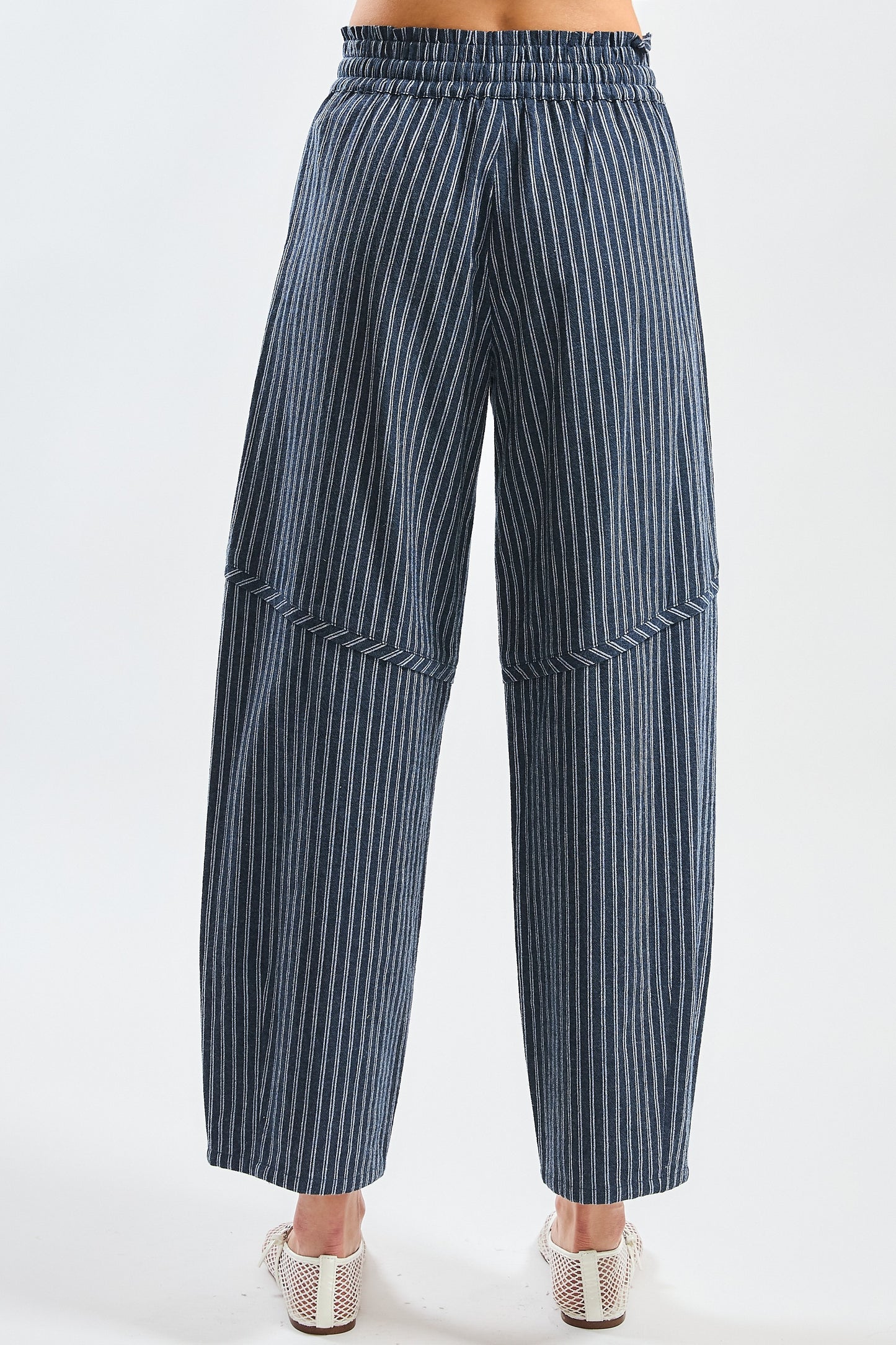 A pair of women's high-waisted wide-leg cropped pants featuring a indigo and white vertical pinstripe pattern with a gathered elastic drawstring waistband and front pockets.
