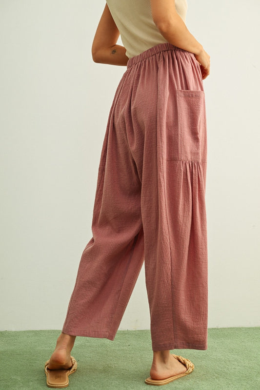 Mauve and stone vertical pinstripe pants featuring a high-rise waist, a relaxed loose-fit silhouette, and functional oversized front patch pockets.