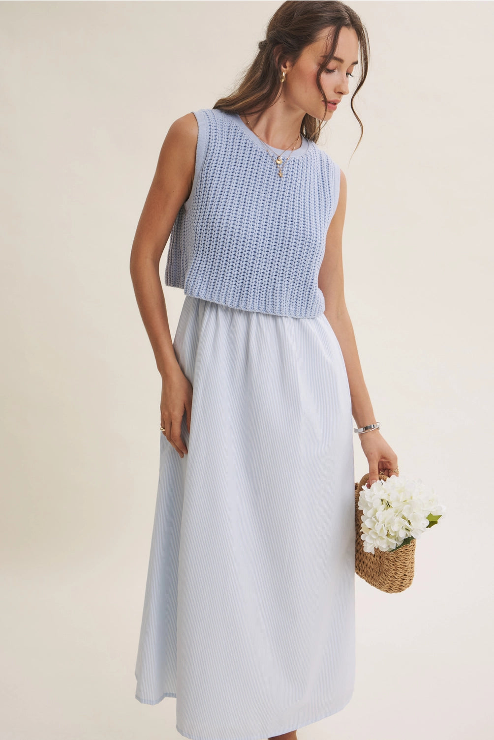 A women's sky blue mixed media midi dress featuring a sleeveless open-knit sweater vest top and an attached gathered striped midi skirt.