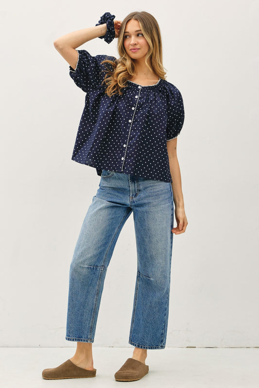 Navy base with white polka dot blouse. With a scoop neckline with white embroidered trim, puff sleeves, lightweight, and flowy fit.