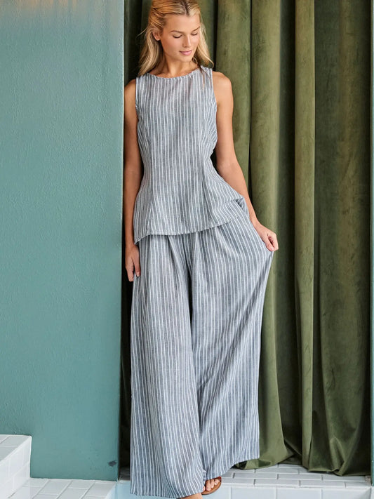 A women's two-piece pinstripe clothing set in a muted gray and white color-way featuring a sleeveless high-neck tunic top and matching high-waisted flowing wide-leg pants with side pockets.
