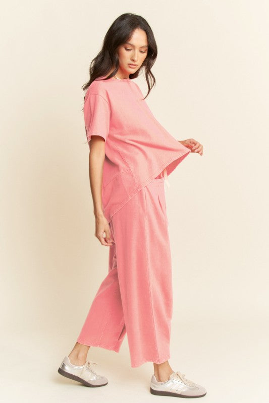 This two-piece cotton set features a hi-low relaxed tee with subtle back pleats and wide-leg drawstring pants with oversized pockets in pink.