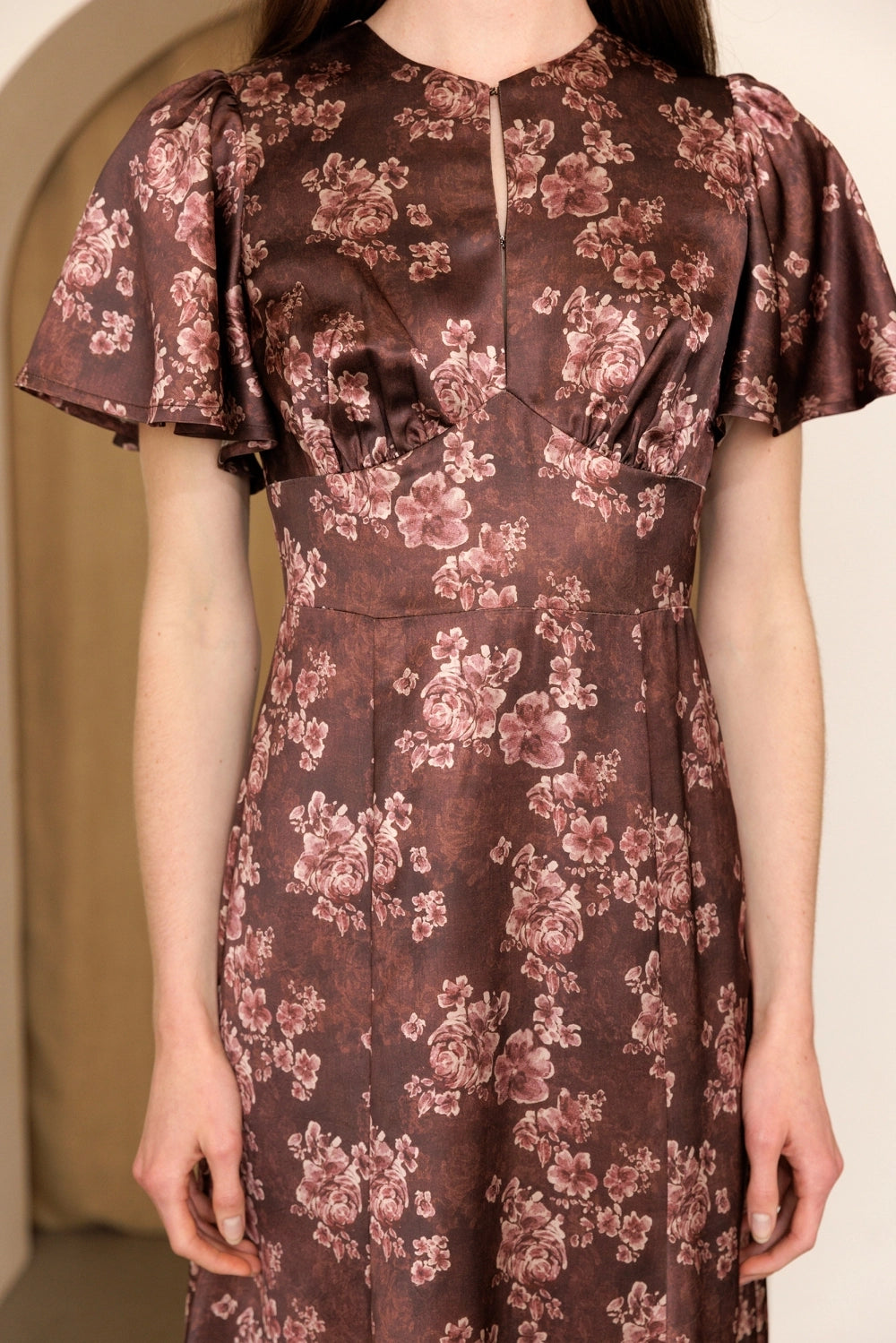 A women's dusty mauve floral print midi dress featuring short flutter sleeves, a structured smocked bodice, and an A-line skirt