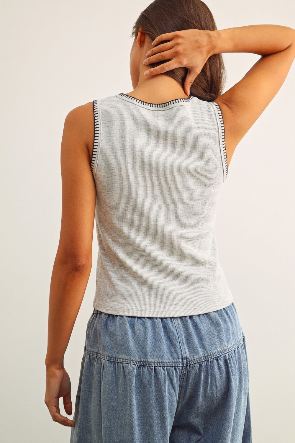 A women's sleeveless crewneck ribbed knit tank top in heather gray featuring a contrasting black blanket-stitch detail along the neckline and armholes.