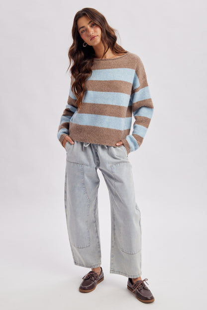 A women's light wash drawstring barrel-leg denim jeans featuring an elastic tie waistband, deep front patch pockets, and curved leg paneling.
