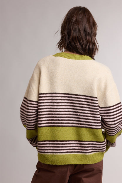 A women's relaxed crewneck knit cardigan featuring wide avocado green colorblocking and horizontal espresso stripes on a cream background with tortoiseshell-look front buttons.