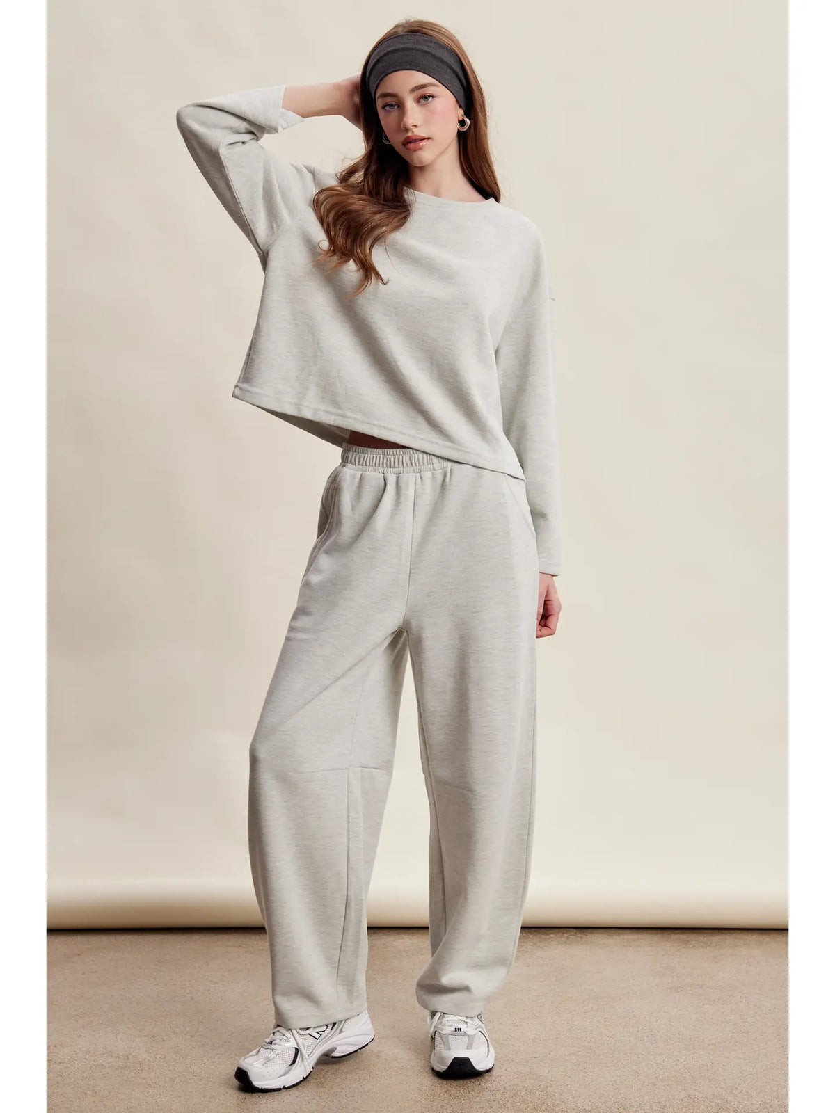 A women's heather gray two-piece stretch cotton lounge set featuring a long-sleeve crewneck top and matching high-waisted relaxed wide-leg pants.