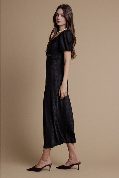 A women's black satin jacquard polka dot midi dress featuring short puff sleeves, a scoop neckline with ruffle trim, and a high empire waistline.