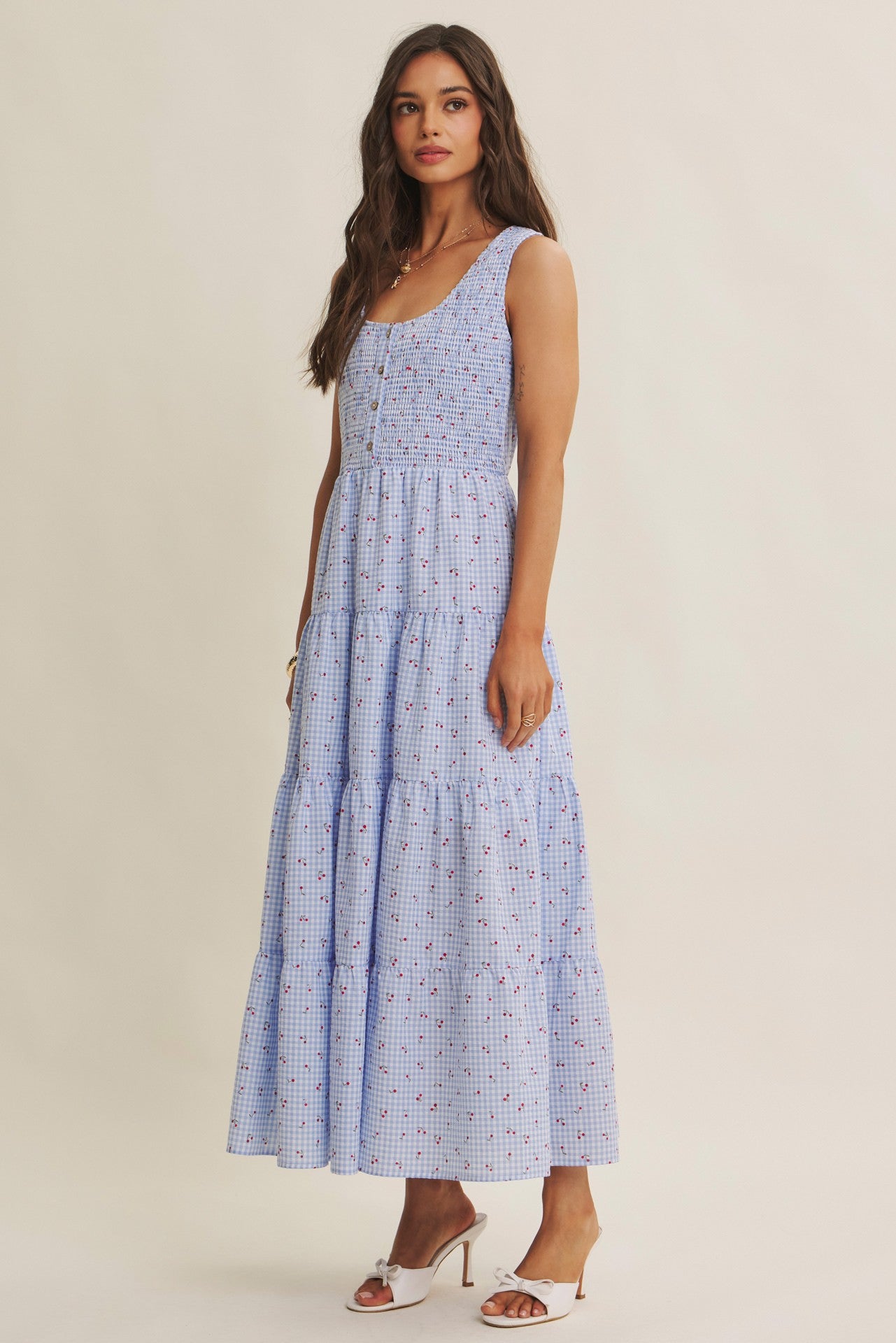 Cherry gingham print maxi dress in the color sky blue. The dress has a smocked bust, round neck, button-down detail, side pockets and comes lined. 