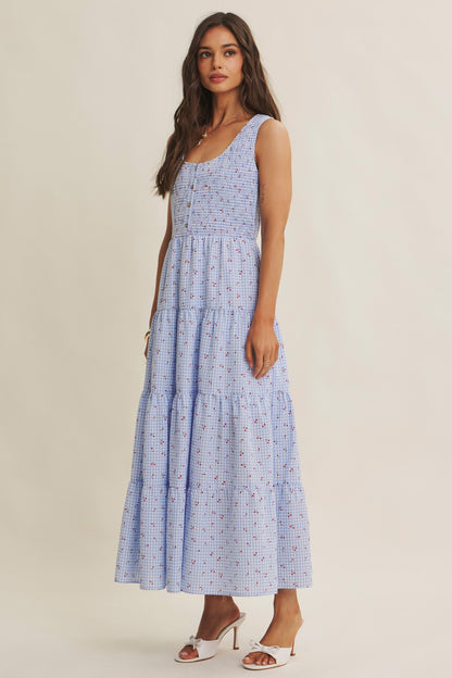 Cherry gingham print maxi dress in the color sky blue. The dress has a smocked bust, round neck, button-down detail, side pockets and comes lined. 