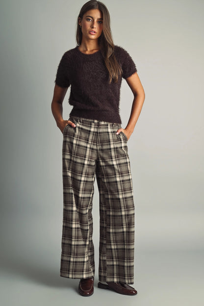 A women's high-waisted wide-leg plaid trousers in black and warm brown featuring front pleats, belt loops, and a relaxed straight drape.