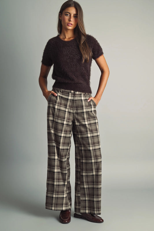 A women's high-waisted wide-leg plaid trousers in black and warm brown featuring front pleats, belt loops, and a relaxed straight drape.