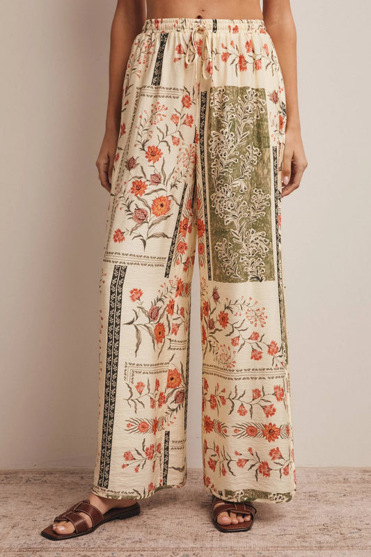 High-waisted wide-leg patchwork floral print pants in ecru, terracotta, and olive green featuring a comfortable elastic drawstring waistband and a relaxed silhouette.
