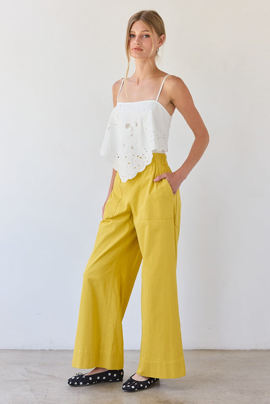 Mustard yellow wide-leg pants featuring a high-rise elastic waistband, a relaxed flowy silhouette, and two functional front patch pockets.