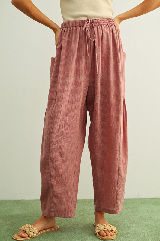 Mauve and stone vertical pinstripe pants featuring a high-rise waist, a relaxed loose-fit silhouette, and functional oversized front patch pockets.