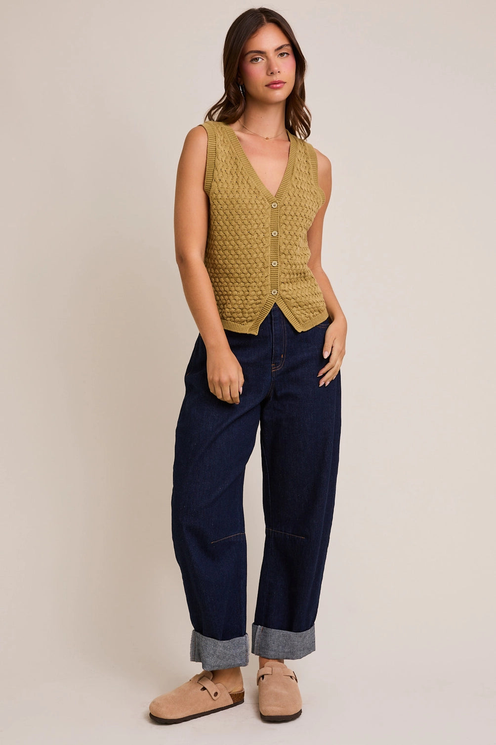A women's sleeveless olive green button-front vest knit top featuring an intricate textured basketweave pattern, a modest V-neckline, and ribbed trim along the split hem.
