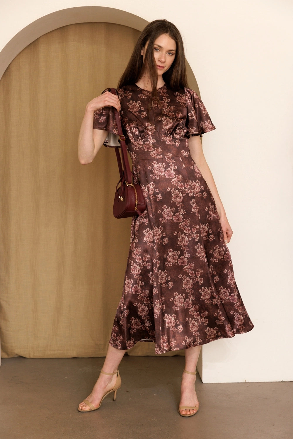 A women's dusty mauve floral print midi dress featuring short flutter sleeves, a structured smocked bodice, and an A-line skirt