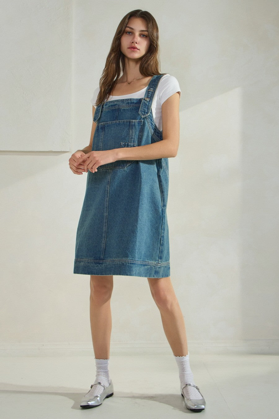 Overall denim dress with large front pocket and side pockets.