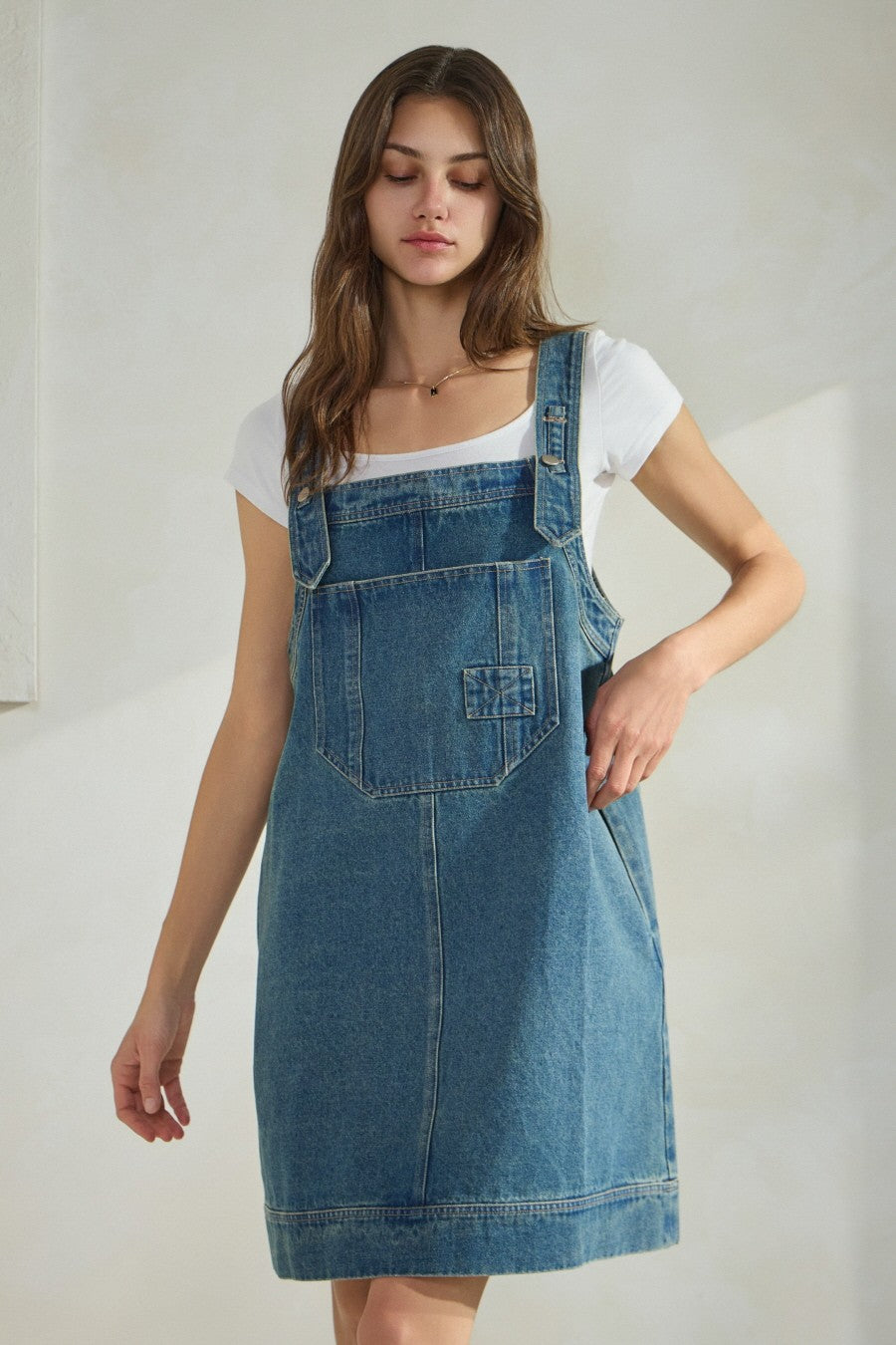 Overall denim dress with large front pocket and side pockets.