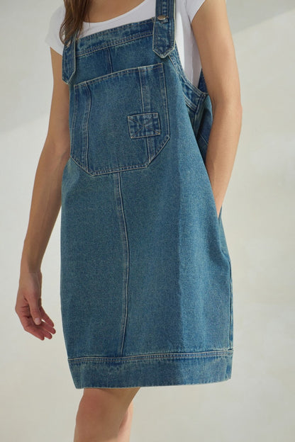 Overall denim dress with large front pocket and side pockets.