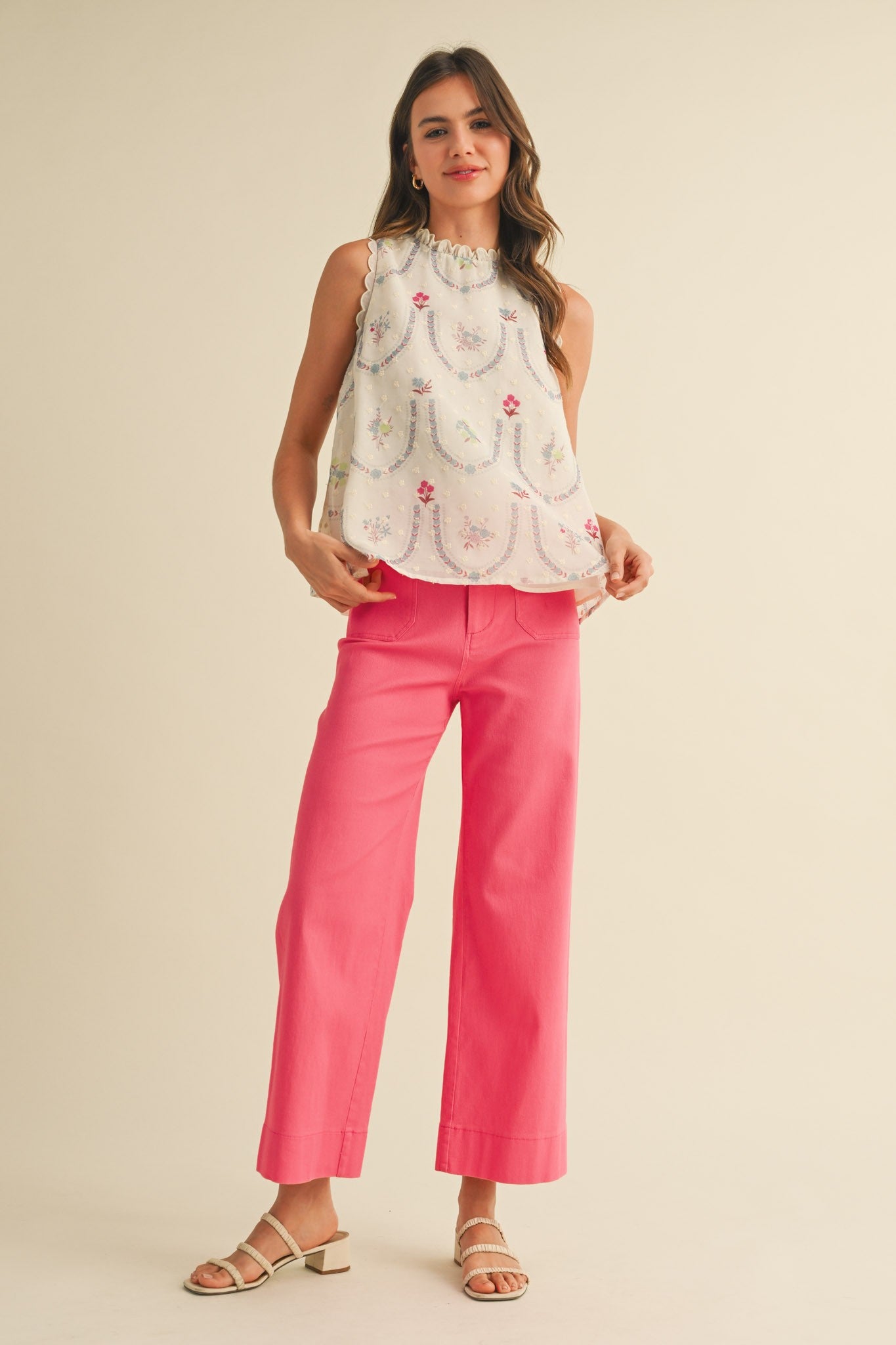 A pair of women's high-waisted wide-leg cropped cotton twill pants in a vibrant berry pink color featuring classic front patch pockets and a button zip closure.