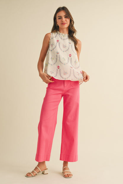 A pair of women's high-waisted wide-leg cropped cotton twill pants in a vibrant berry pink color featuring classic front patch pockets and a button zip closure.