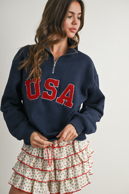 Long-sleeve pullover, half-zip navy sweater with felted USA in the center. 
