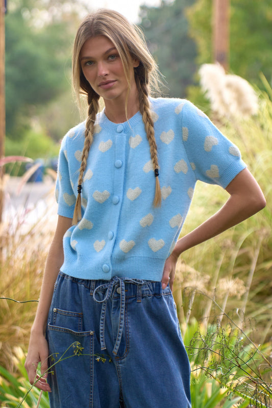 Short sleeve sky blue knit cardigan with chunky buttons with white hearts. 