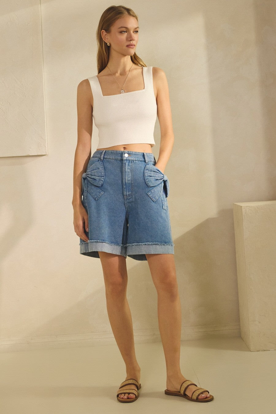 Bow Pocket Short in Washed Denim. Cuffed hem, button and zipper closure, smocking on the back, and a 6.5" inseam. 