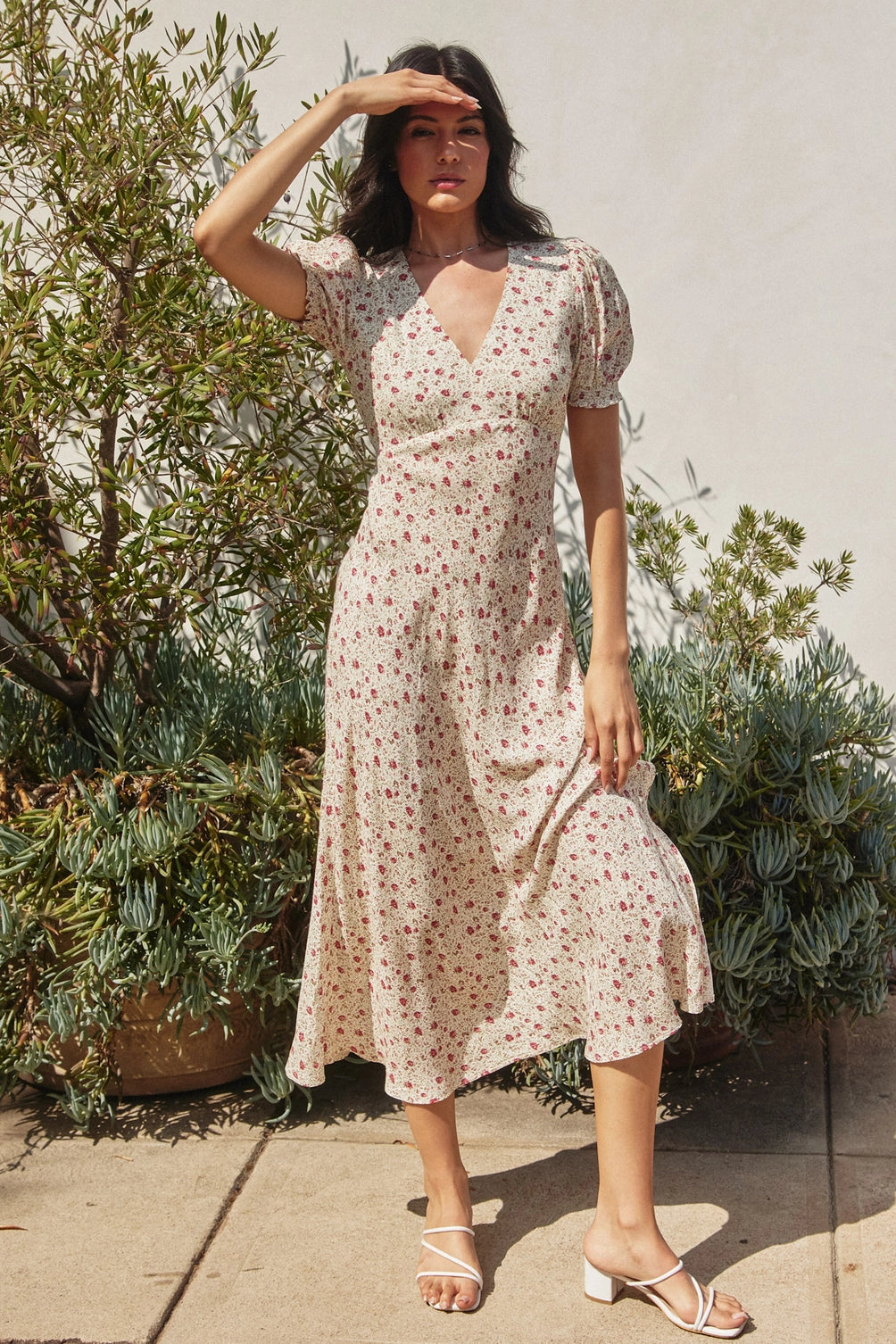 A women's short puff sleeve maxi dress in cream featuring a ditsy rose pink floral print, a modest surplice V-neckline, and a flowing skirt.