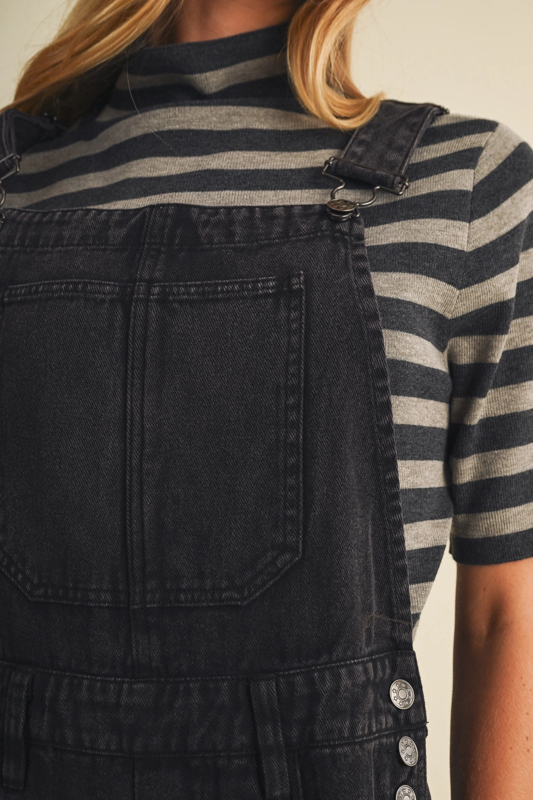 A pair of women's high-waisted wide-leg twill overalls in a vintage washed black denim finish featuring classic adjustable shoulder straps, a front chest pocket, and side pockets.