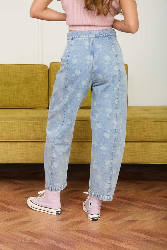 Dandelion printed cropped slight barrel light wash denim jeans. Button and zipper closure with a waist tie. No back pockets. 