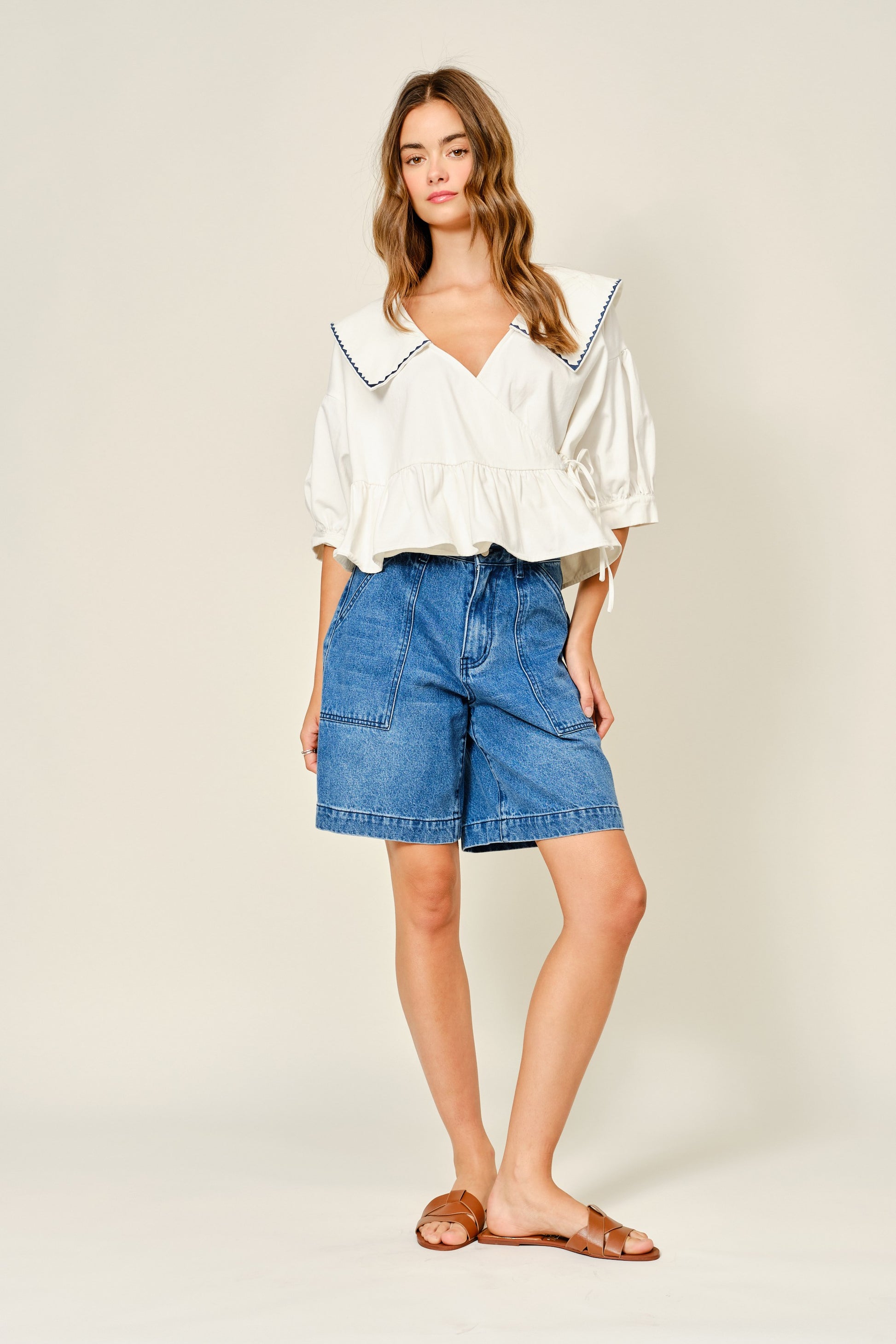 Medium Wash denim bermuda shorts. Large front pockets. Button and zipper closure. Back pockets. 