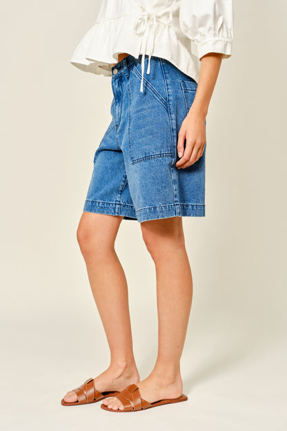 Medium Wash denim bermuda shorts. Large front pockets. Button and zipper closure. Back pockets. 