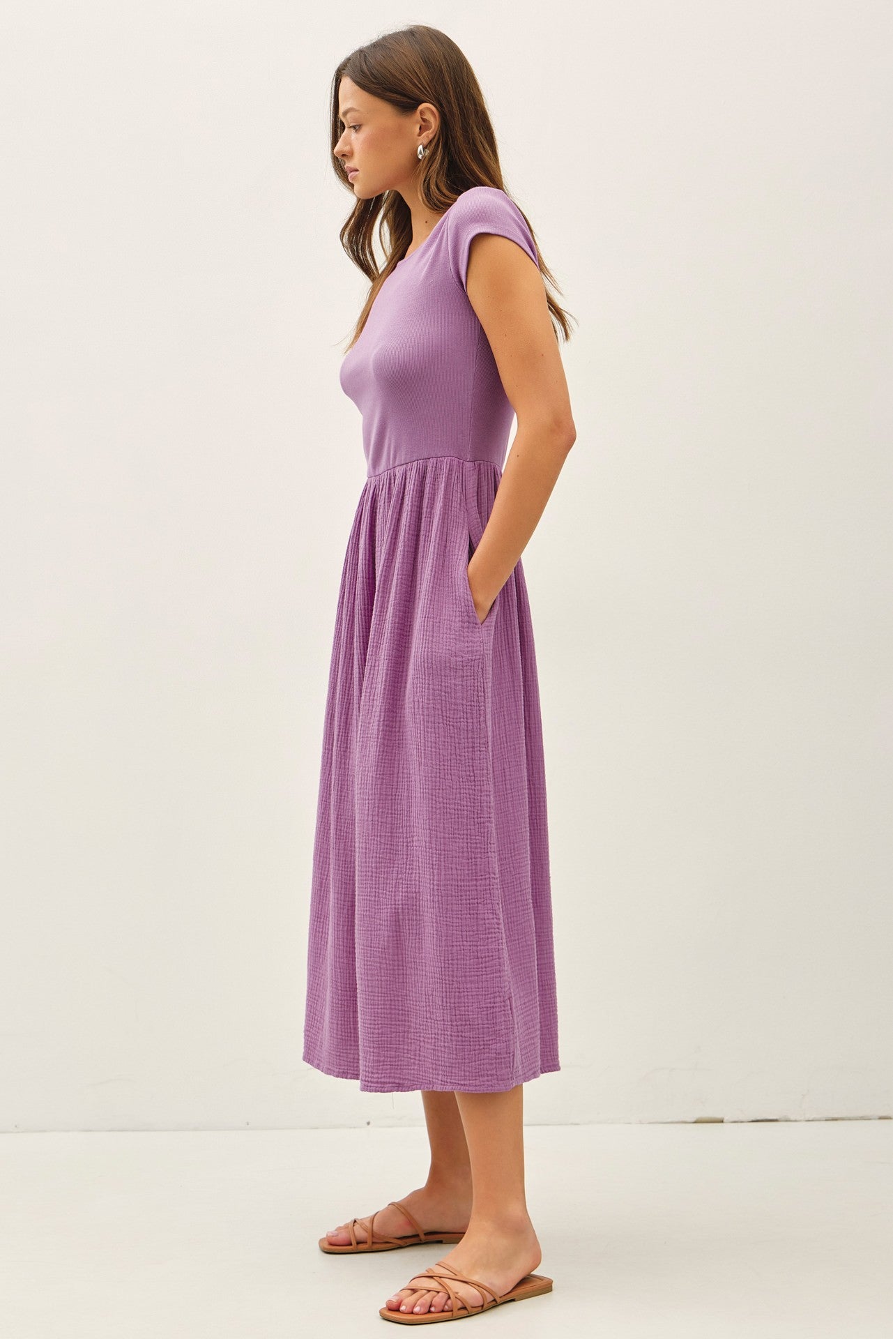 iris purple midi dress featuring a wide boat neckline, short cap sleeves, and a soft gathered waistline with a relaxed flowy skirt.