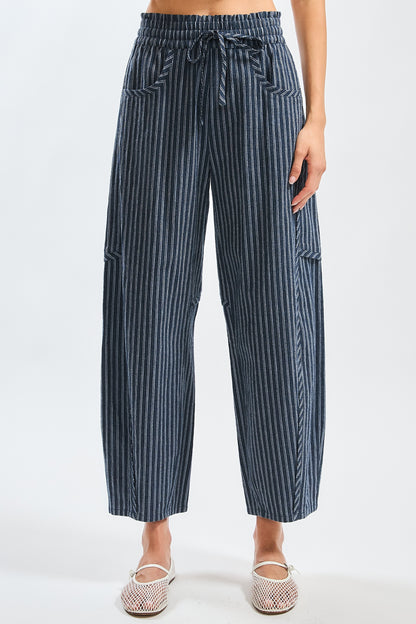A pair of women's high-waisted wide-leg cropped pants featuring a indigo and white vertical pinstripe pattern with a gathered elastic drawstring waistband and front pockets.