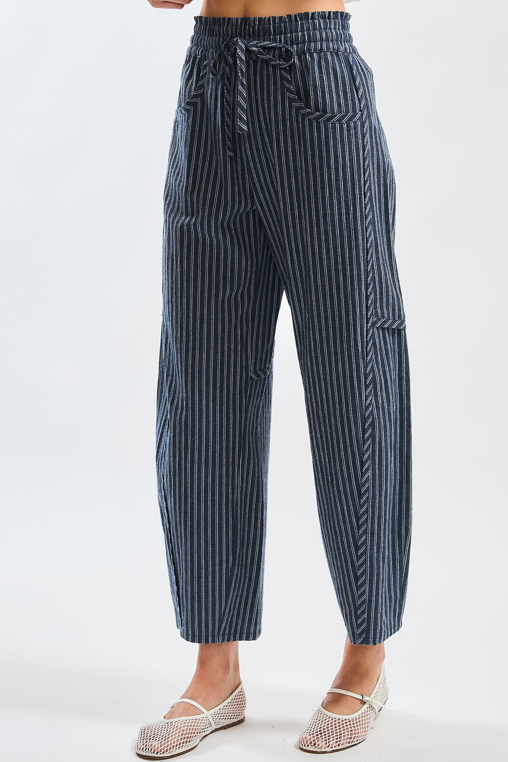 A pair of women's high-waisted wide-leg cropped pants featuring a indigo and white vertical pinstripe pattern with a gathered elastic drawstring waistband and front pockets.