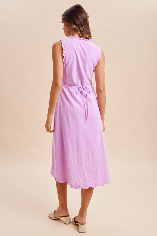 Sleeveless Button-Down Midi Dress with scalloped hem, ruffled mock neck, and ruffled armholes.  Button-down front closure and tie-waist detail, side pockets, and an inner lining.