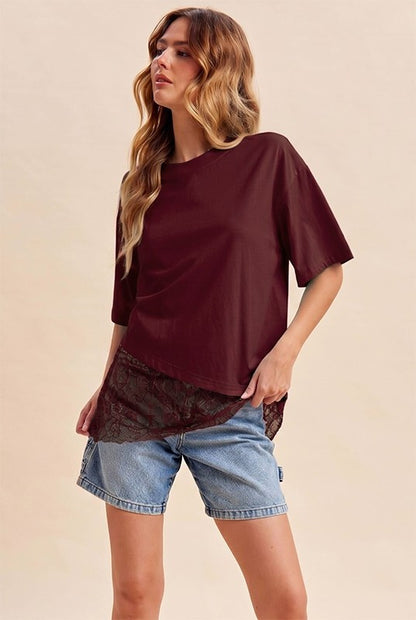A women's relaxed short-sleeve burgundy crewneck T-shirt featuring dropped shoulders and an asymmetrical hem trimmed with sheer floral lace.