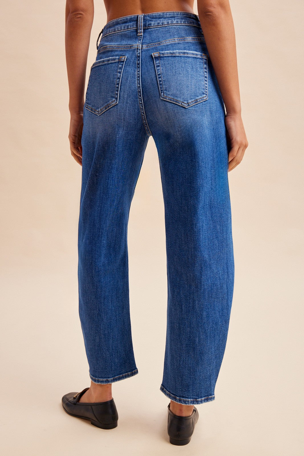 Stretch denim slim barrel leg jeans in dark wash denim featuring a high-rise waist, angled front utility patch pockets, and distinct center seam detailing down each leg.