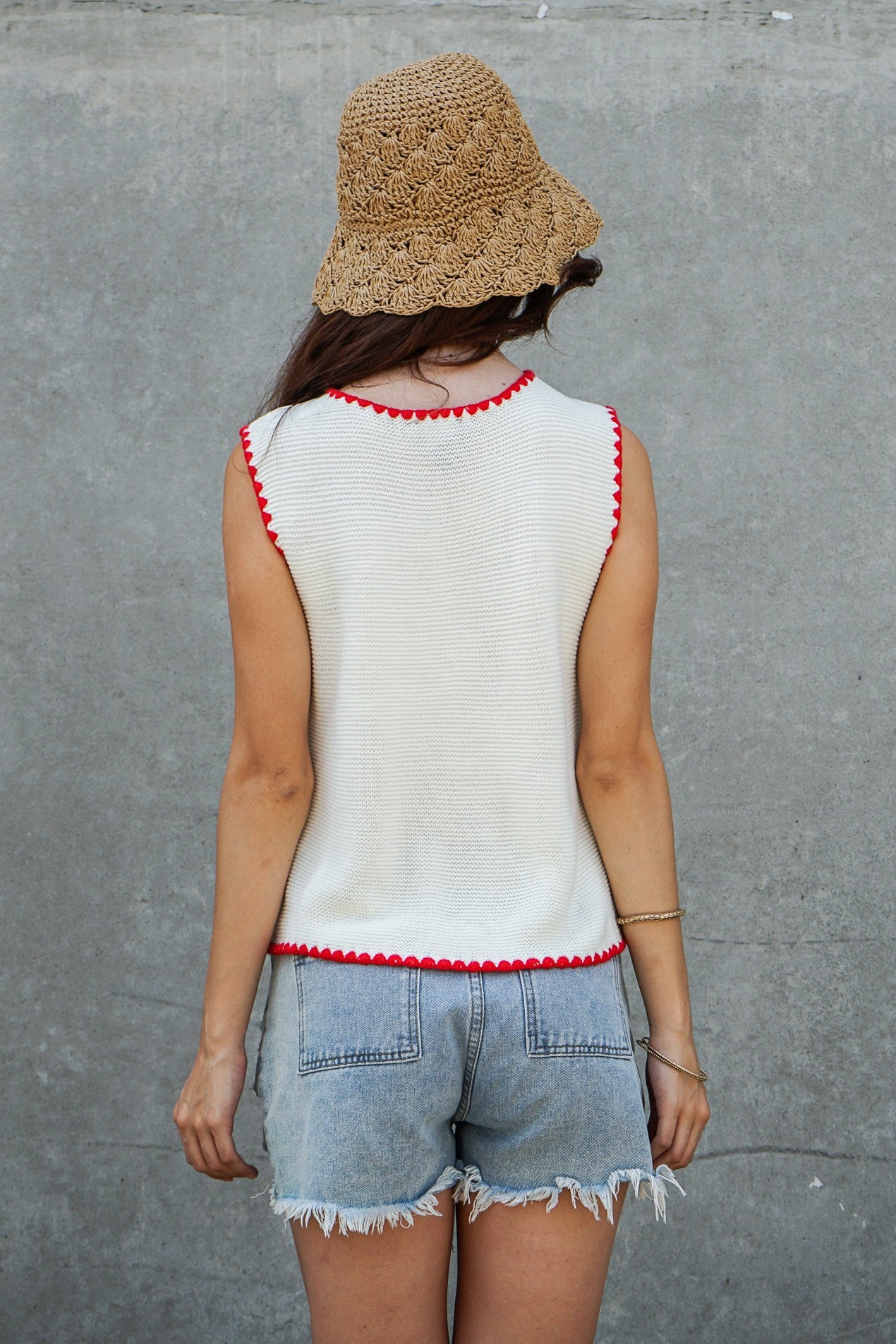 A women's sleeveless textured knit button-down vest tank top in ivory featuring a red scalloped contrast trim along the neckline, front placket, armholes, and hem.