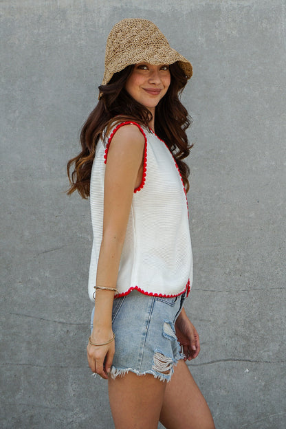 A women's sleeveless textured knit button-down vest tank top in ivory featuring a red scalloped contrast trim along the neckline, front placket, armholes, and hem.