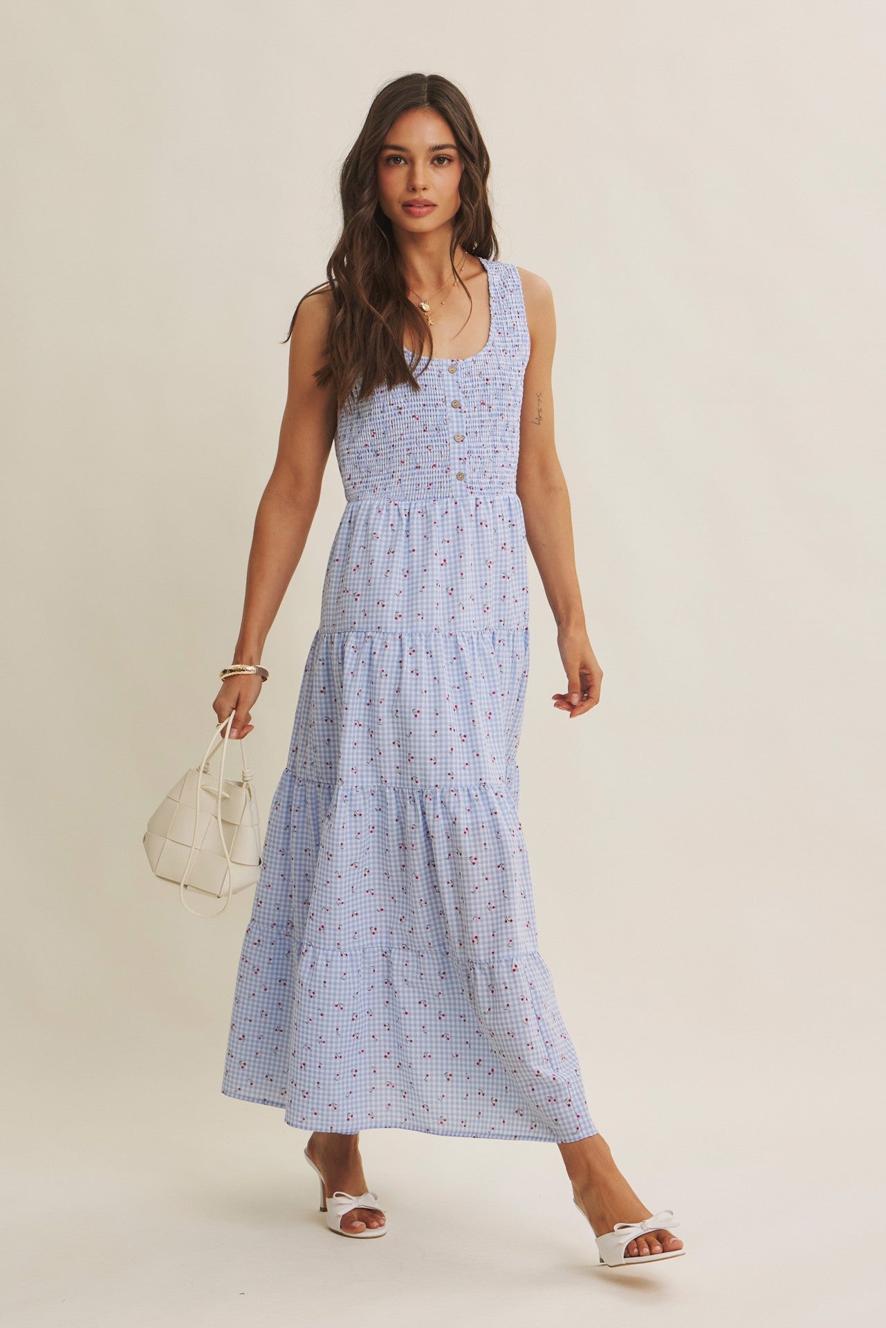 Cherry gingham print maxi dress in the color sky blue. The dress has a smocked bust, round neck, button-down detail, side pockets and comes lined. 