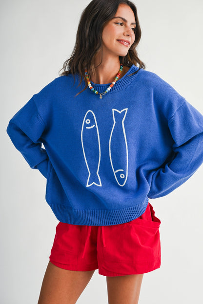 A women's royal blue long-sleeve knit crewneck sweater featuring a white embroidered sardine graphic on the front and ribbed trim along the collar, cuffs, and hem.