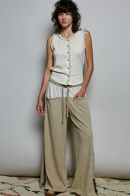 A women's sleeveless cream textured waffle-knit top featuring a button-front closure and delicate eyelet lace trimming along the round neckline and armholes.