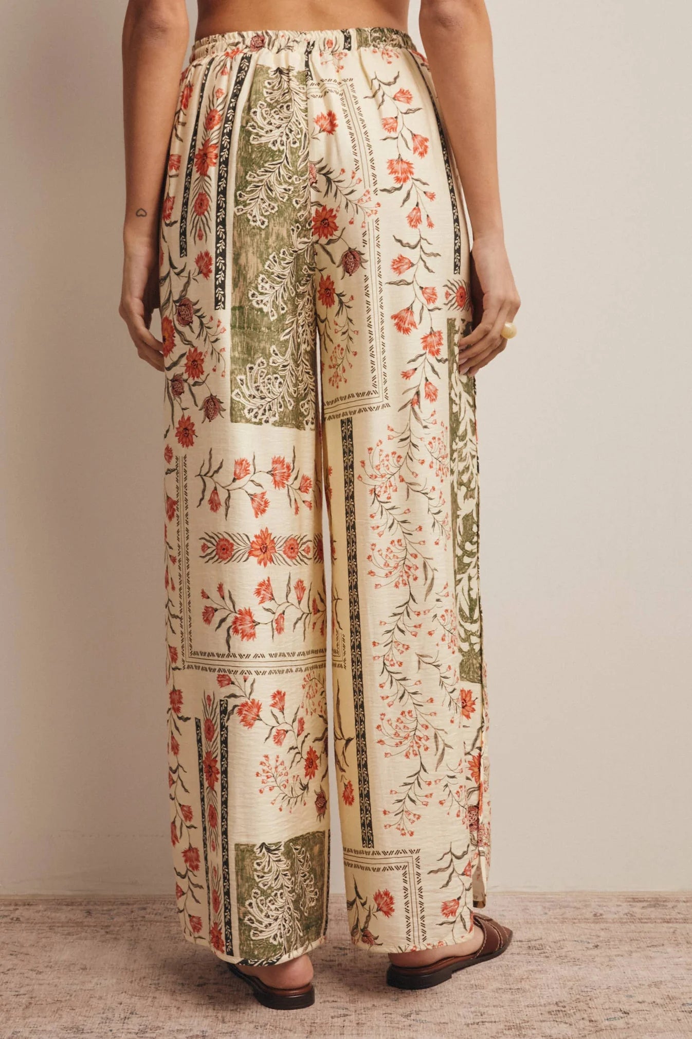 High-waisted wide-leg patchwork floral print pants in ecru, terracotta, and olive green featuring a comfortable elastic drawstring waistband and a relaxed silhouette.
