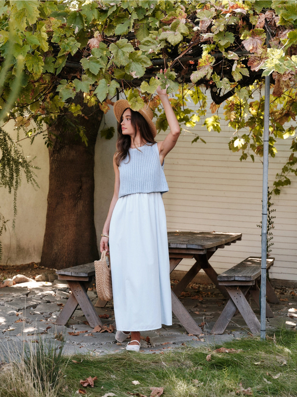 A women's sky blue mixed media midi dress featuring a sleeveless open-knit sweater vest top and an attached gathered striped midi skirt.