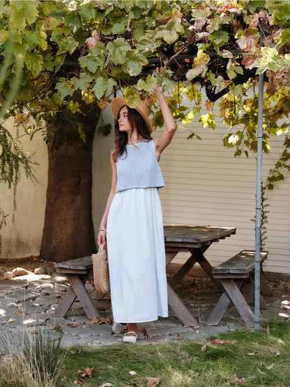 A women's sky blue mixed media midi dress featuring a sleeveless open-knit sweater vest top and an attached gathered striped midi skirt.
