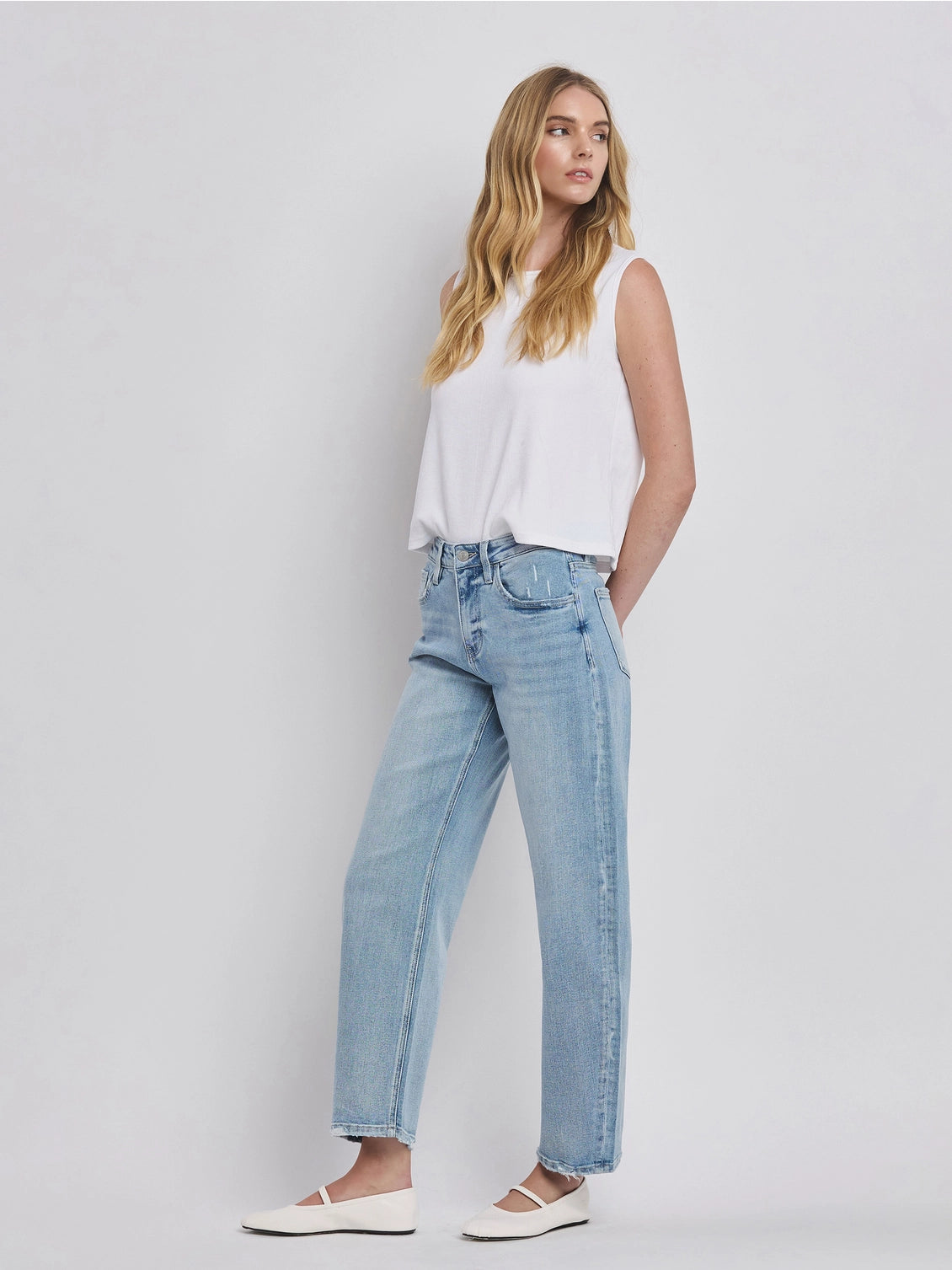 Women's light wash high-rise barrel leg jeans featuring a relaxed curved silhouette, subtle distressing, and an ankle-length hem.